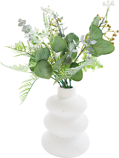 Decorative greenery arrangement in a white ceramic vase